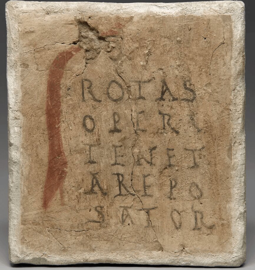A weathered stone tablet incised with the Sator Square, its five words carved in
                      five rows: rotas, opera, tenet, arepo, sator.